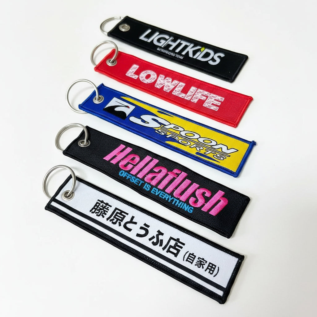 Collection of colorful keychains with various text and branding on a wooden surface